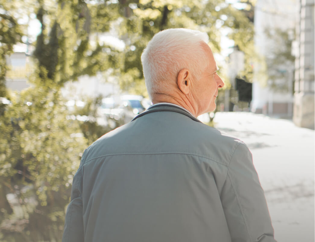 uomo anziano di spalle che cammina all'aperto, simbolo di tranquillità e consapevolezza